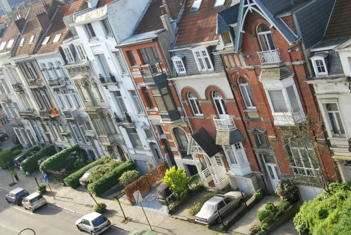 Row of residential houses with cars parked outside.